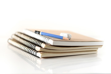 Education,Stack of notebook with pencil and eraser on white background