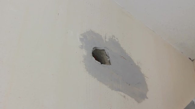 Worker is applying skim coating material around wall socket before painting
Painter is smoothing wall around socket before painting with trowel, skim coating.
