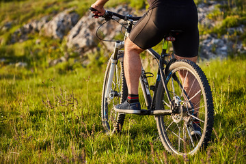 Obraz premium Close-up of detail of cyclist man feet riding mountain bike on rocky trail.