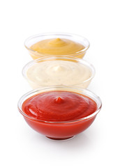 Bowls with ketchup mustard and mayonnaise isolated on white background.