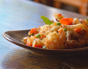 Fried shrimp with herb on wooden table.
