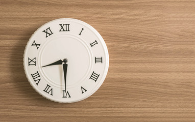 Closeup white clock for decorate show half past eight o'clock or 8:30 a.m. on wood desk textured background with copy space