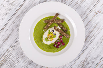 Cooking with local ingredients - poached egg and green healthy soup, close up