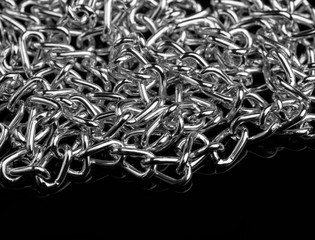 Chain heap - abstract metal background. Collection silver jewelry chains on an isolated black...