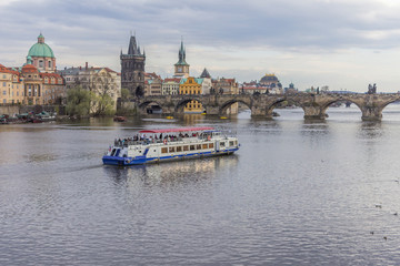 Obraz premium View of the Charles Bridge and pleasure craft from the side of the Manes Bridge. The River Vltava. Area of the Old Town. Prague, Czech Republic.