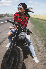 Fototapeta na wymiar Biker girl sitting on motorcycle