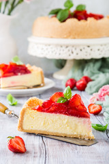 Piece of delicious homemade strawberry cheesecake and flowers on gray stone background. Selective focus.