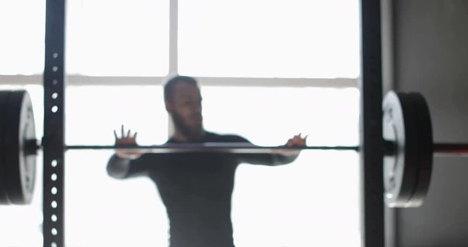 Young Man Exercising Doing Weighted Squats On Smith Machine During Workout Training At Gym Male Athlete Fitness