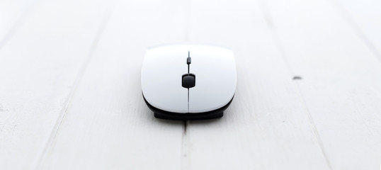 White wireless mouse with pad on a wooden background