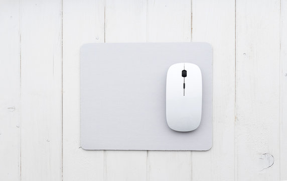 White wireless mouse on a mouse pad, top view