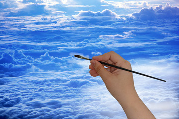 Hand hold paintbrush to paint cloud with blue sky