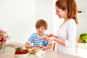happy mother and son preparing snacks in the morning at home kitchen