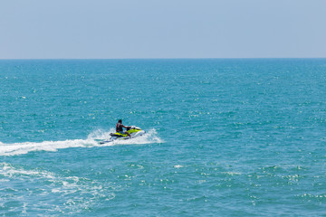 Fototapeta na wymiar Man riding a water scooter at sea