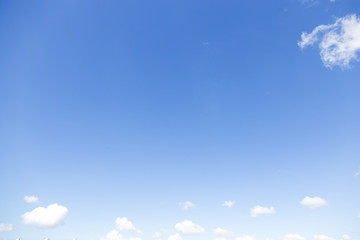 The blue summer sky, with light clouds above the horizon and one cloud at the top.