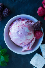 The white-pink ice cream top with berries marshmallow and mint on the slate