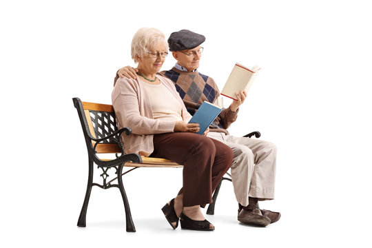 Mature couple sitting on a bench and reading books