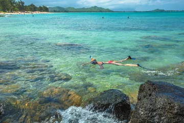 Fotobehang Woman snorkelling over coral reef in kailua beach, east shore in Oahu island, Hawaii, USA. Female bikini snorkeler swims in tropical sea. Watersport activity in Hawaii. Tropical destination holidays. © bennymarty