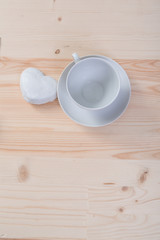 one pure white ceramic Cup and saucer and gingerbread stands on a wooden table