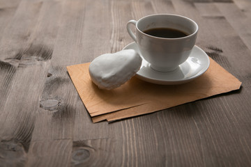white coffee cup and gingerbread on wooden desk