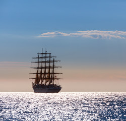The world's largest sailing ship with five masts leaves at sunset in the open sea