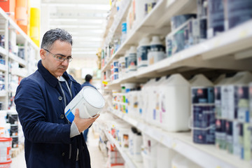 Man choosing paint on the shelves of a hardware store - 158581684