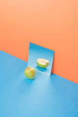Apple on blue table isolated over orange background
