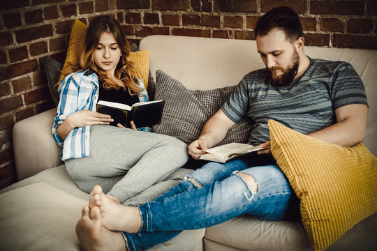 Couple reading books in living room