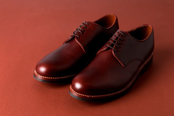 Brown oxford shoes on red background. Close up.