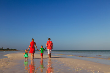 happy family with two kids walking on beach