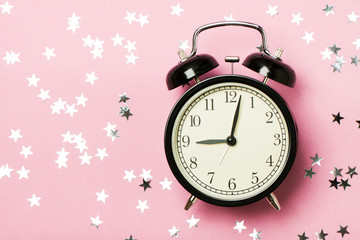 Alarm clock on the pink background