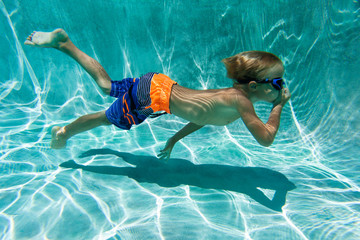 little boy learns swimming underwater