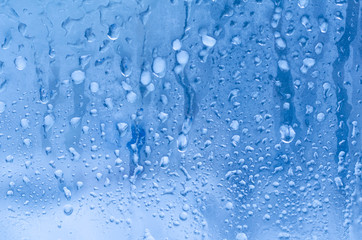 Naklejka na ściany i meble Rain drops and frozen water on window glass background