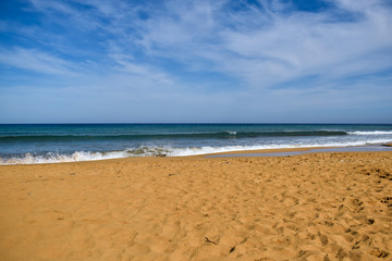 Fototapeta na wymiar Splashing waves on sandy beach