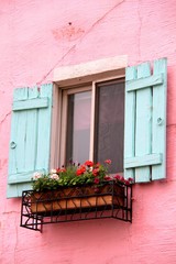 Pink wall of a house with blue window in La Provence Village. Colorful sights in  French style, South Korea.