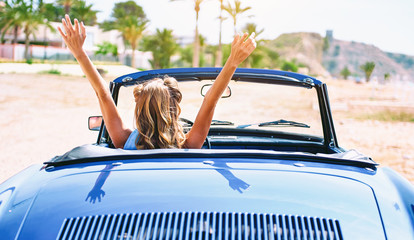 Woman sitting in retro cabriolet car. Back view