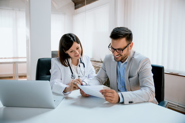 Male patient consulting doctor in clinic