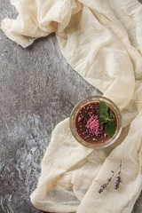 Obraz na płótnie Canvas Italian dessert. Panna cotta with pink sugar and mint. Grey stone background. Fabric milky. Top view.
