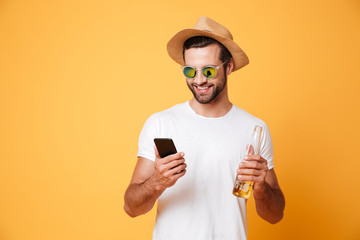 Happy young man standing isolated over yellow background