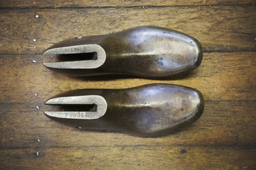 A pair of metal shoe forms, shoe lasts, in a shoemaker's workshop.
