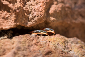 two golden wedding rings in the cleft of the rock, wedding rings background concept
