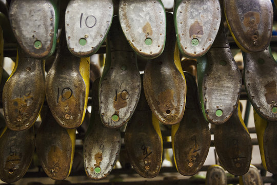 Close up of various metal shoe forms or lasts in a shoemaker's workshop.