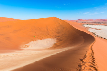 The scenic Sossusvlei and Deadvlei, clay and salt pan surrounded by majestic sand dunes. Namib Naukluft National Park, travel destination in Namibia. Ultra wide.