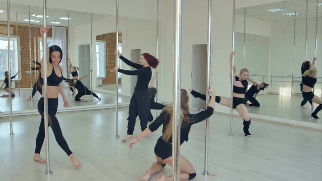 Group of hispanic women stretching and warming up for their pole dancing class