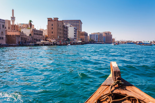 Panoramic view from traditional water taxi boats in Dubai, UAE. Creek gulf and Deira area. United Arab Emirates famous tourist destination.