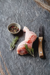 Chicken legs with rosemary and spices. Dark background. Lunch on the grill. Space for text. Top view