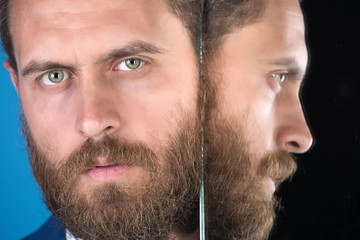 face of serious bearded hipster man, businessman reflecting in mirror