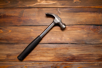 Iron hammer on wooden background. Top view