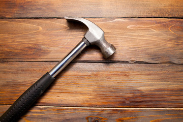 Iron hammer on wooden background. Top view
