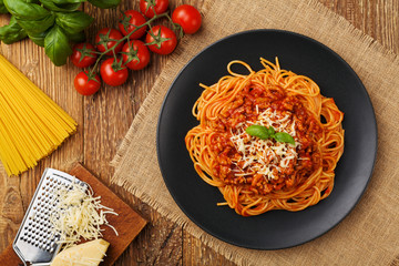 Delicious spaghetti served on a black plate - obrazy, fototapety, plakaty