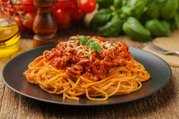 Delicious spaghetti served on a black plate - obrazy, fototapety, plakaty